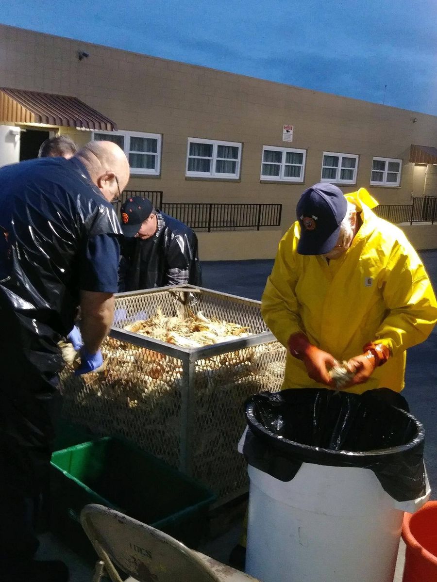 Volunteers in rain gear sorting crab outside the fire station